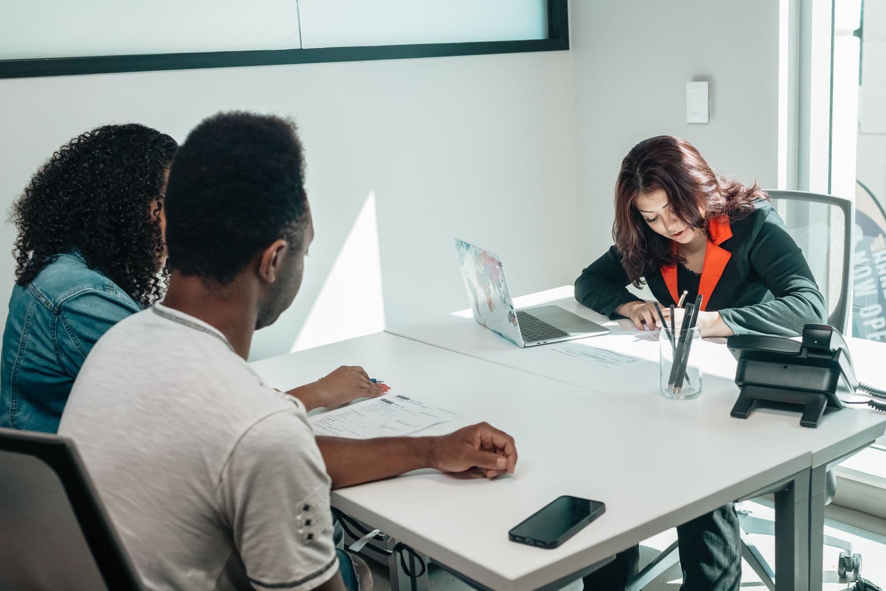 A couple reviewing documents with a professional at a desk
