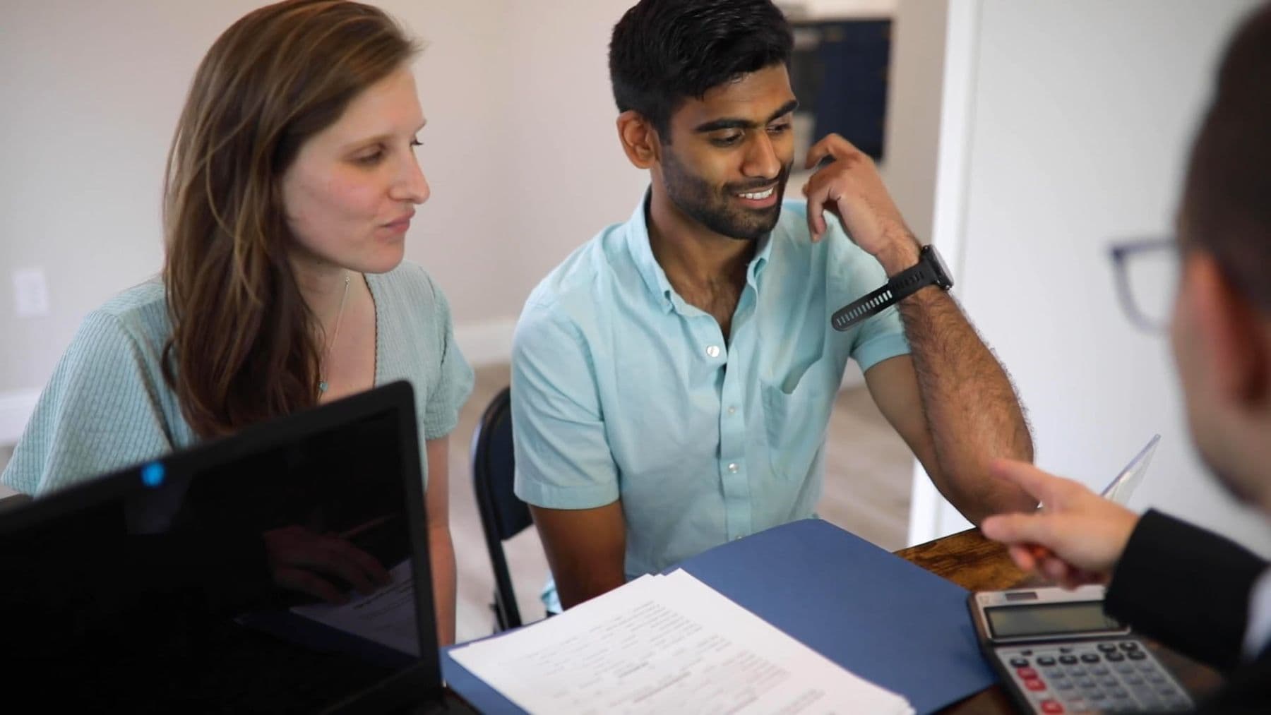 A couple reviewing mortgage documents with an advisor at a table